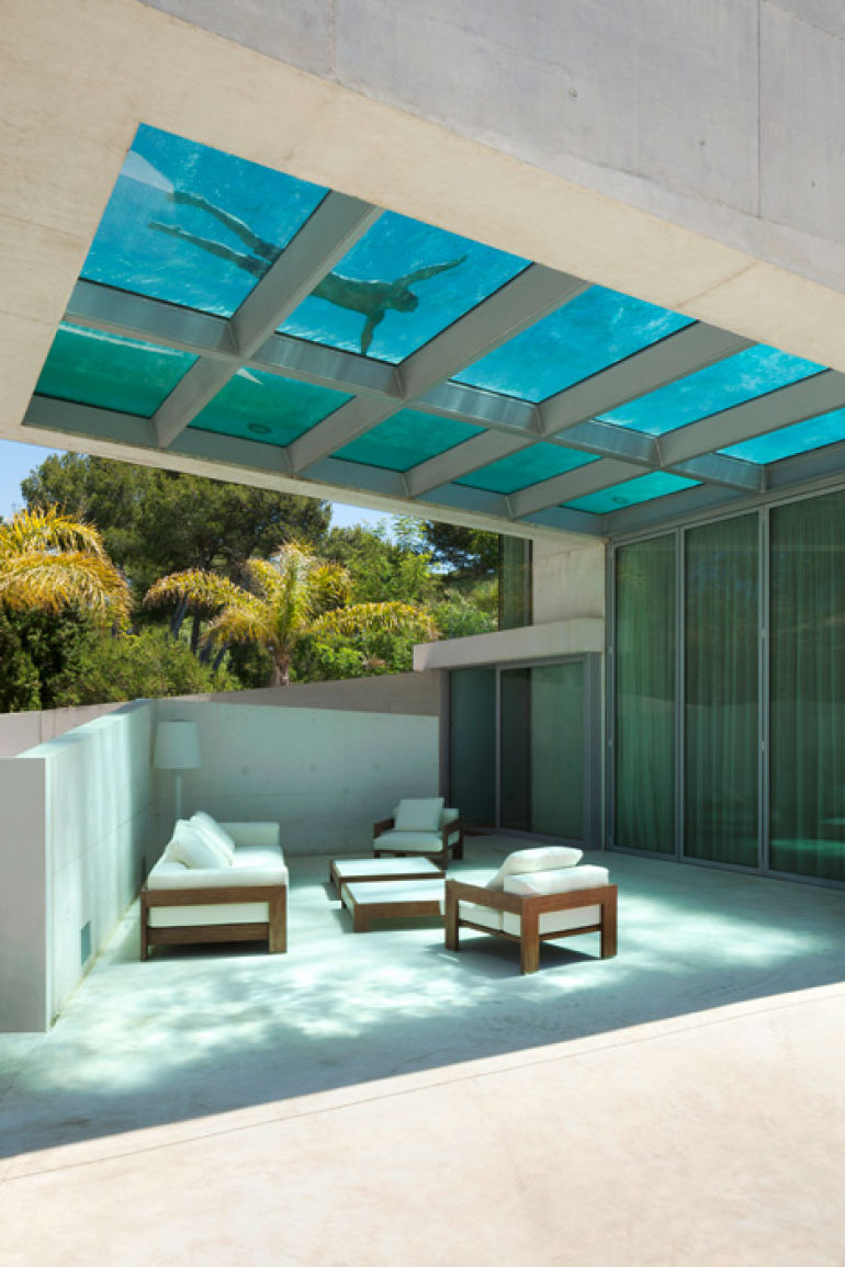 Pool with a see-through bottom over the top of an outdoor sitting area