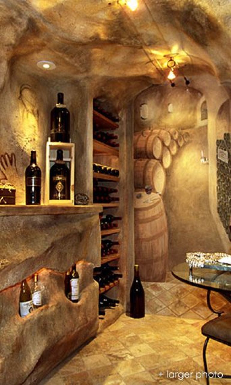 Cave-like wine cellar with trompe l'oeil on wall